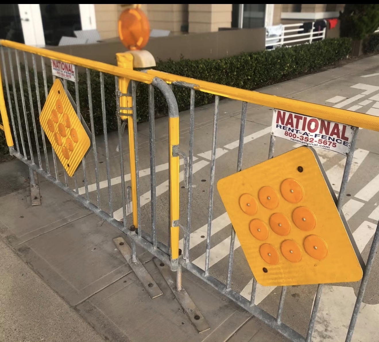 A flashing pedestrian-safety beacon sign on a street corner.